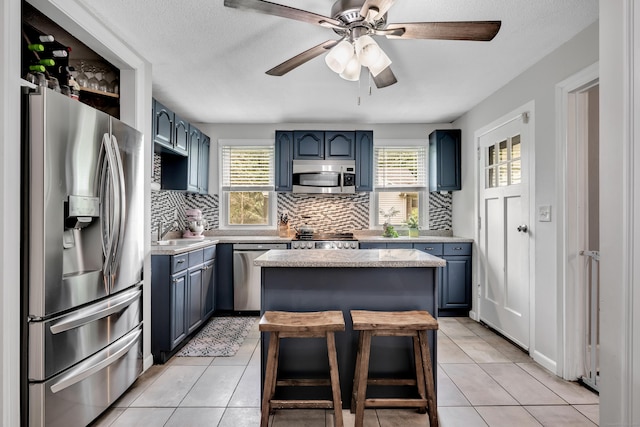 242 Park Ave, Bloomfield, CT 06002 - kitchen with appliances with stainless steel finishes, blue cabinetry, light countertops, tasteful backsplash, and a textured ceiling