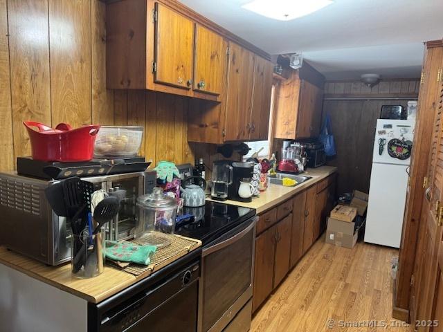 21 Clinic Rd, Pomfret, CT 06230 - kitchen with fridge, electric range, light wood finished floors, light countertops, and brown cabinetry