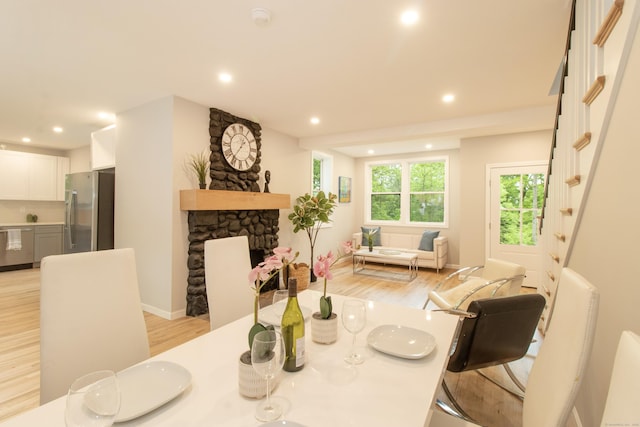 708 County Rd, Guilford, CT 06437 - dining room featuring light wood-style flooring, recessed lighting, a fireplace, baseboards, and stairs