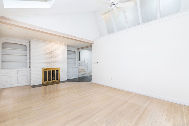 39 Chestnut Hill Rd, Simsbury, CT 06092 - unfurnished living room with wood finished floors, stairs, high vaulted ceiling, a brick fireplace, and baseboards