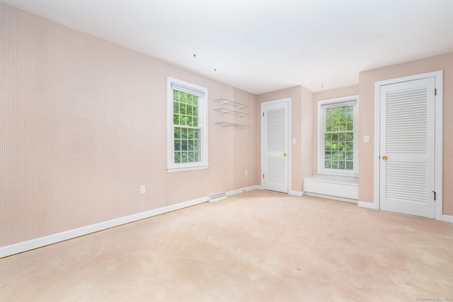 39 Chestnut Hill Rd, Simsbury, CT 06092 - unfurnished bedroom with multiple windows, baseboards, light colored carpet, and multiple closets