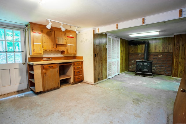106 Hedgehog Ln, Simsbury, CT 06092 - kitchen featuring open shelves, concrete flooring, a wood stove, light countertops, and wooden walls