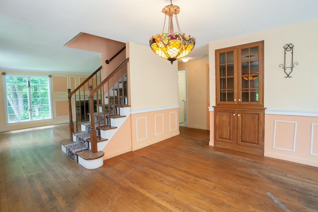 106 Hedgehog Ln, Simsbury, CT 06092 - stairway featuring wood finished floors, a decorative wall, and a wainscoted wall