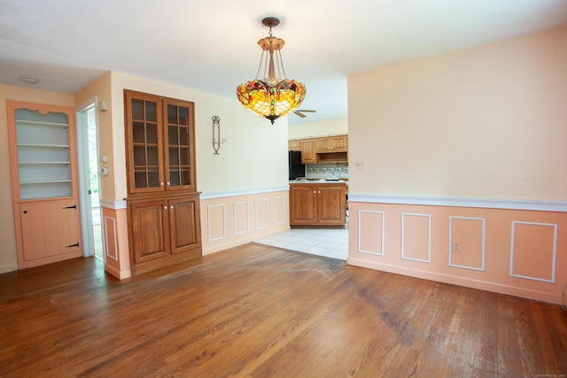 106 Hedgehog Ln, Simsbury, CT 06092 - unfurnished dining area featuring light wood finished floors, a wainscoted wall, a decorative wall, and built in features