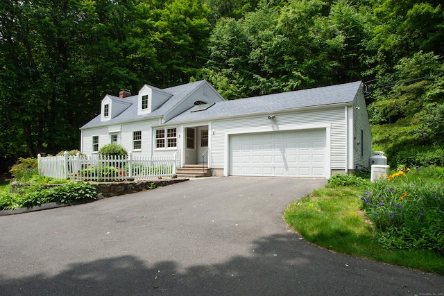 106 Hedgehog Ln, Simsbury, CT 06092 - new england style home featuring asphalt driveway, an attached garage, a chimney, a shingled roof, and a view of trees