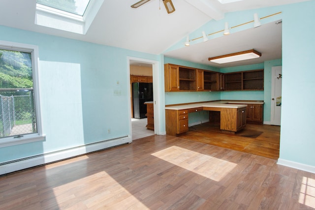 106 Hedgehog Ln, Simsbury, CT 06092 - kitchen featuring open shelves, a skylight, black fridge, a baseboard radiator, and light countertops
