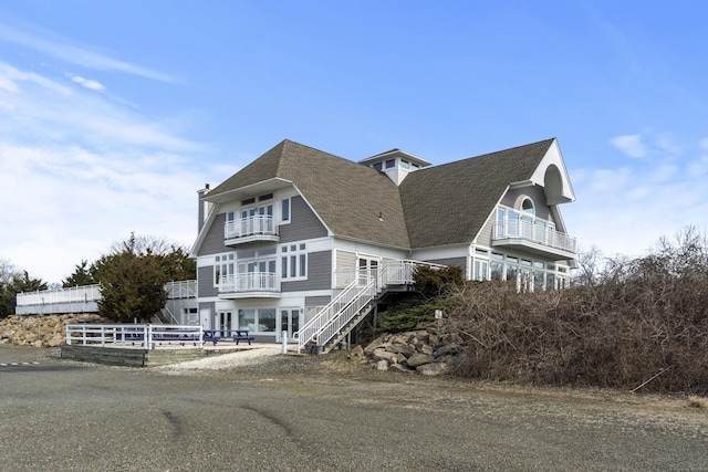 379 Whitfield St Unit Bs1138, Guilford, CT 06437 - view of home's exterior featuring a balcony, roof with shingles, stairway, and a chimney