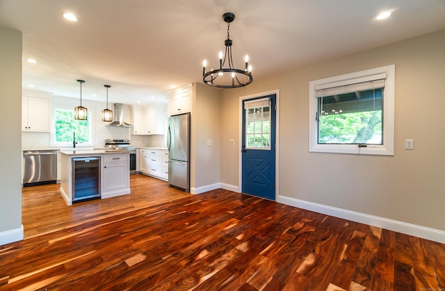 251 Forest Rd, North Branford, CT 06472 - kitchen featuring appliances with stainless steel finishes, beverage cooler, wall chimney exhaust hood, baseboards, and dark wood-type flooring