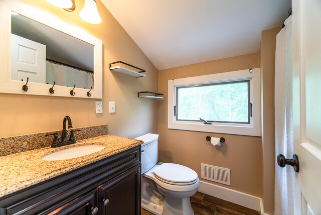 251 Forest Rd, North Branford, CT 06472 - bathroom with vaulted ceiling, wood finished floors, vanity, toilet, and baseboards