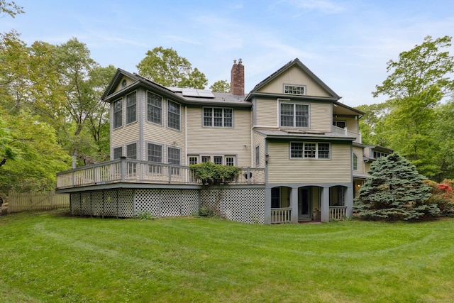 143 Petticoat Ln, East Haddam, CT 06423 - rear view of property featuring a chimney, solar panels, a yard, and a wooden deck