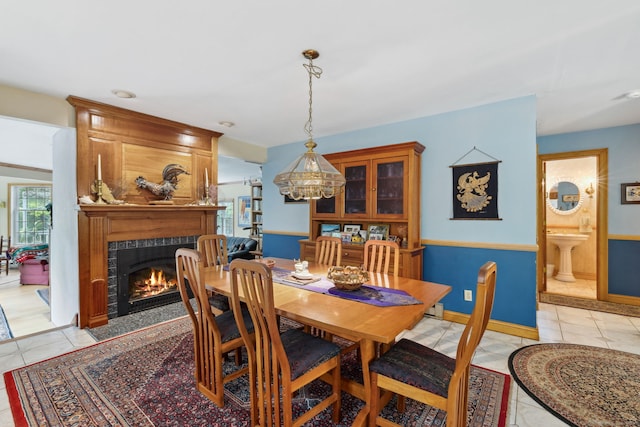 143 Petticoat Ln, East Haddam, CT 06423 - dining area with a fireplace, light tile patterned floors, and baseboards