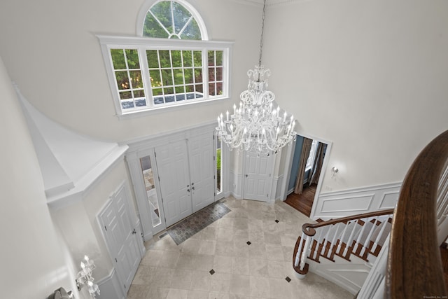 8 Hollow Oak Rd, Woodbridge, CT 06525 - tiled entryway with a towering ceiling, a chandelier, ornamental molding, and a decorative wall