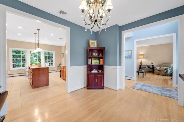 244 S St, Vernon, CT 06066 - dining area with a baseboard heating unit, a chandelier, a baseboard radiator, light wood-type flooring, and a wainscoted wall