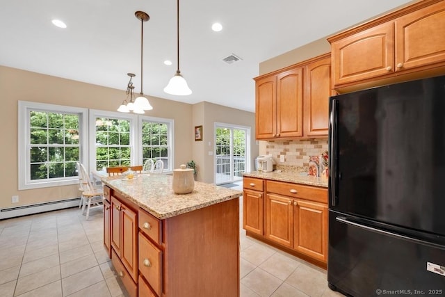 244 S St, Vernon, CT 06066 - kitchen with freestanding refrigerator, a kitchen island, light stone countertops, a baseboard heating unit, and light tile patterned floors