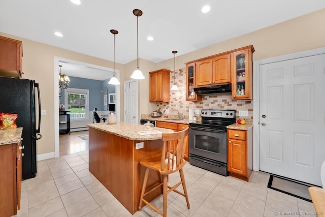244 S St, Vernon, CT 06066 - kitchen with electric range, under cabinet range hood, freestanding refrigerator, a sink, and brown cabinets