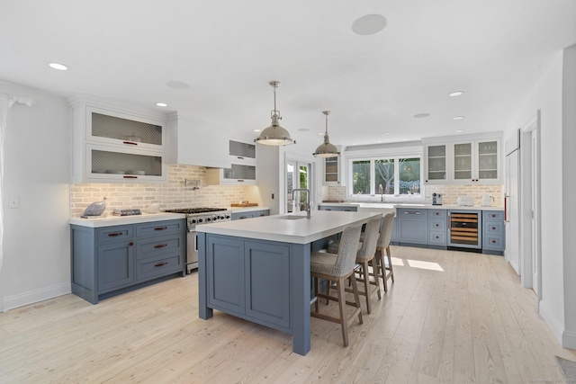 5 Compo Hill Ave, Westport, CT 06880 - kitchen featuring wine cooler, stainless steel range, a sink, decorative backsplash, and light countertops