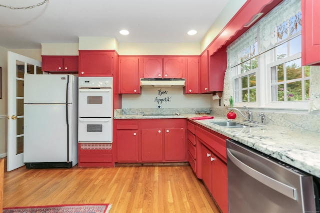 10 Crossland Pl, Norwalk, CT 06851 - kitchen featuring white appliances, red cabinets, under cabinet range hood, a sink, and light wood-style flooring