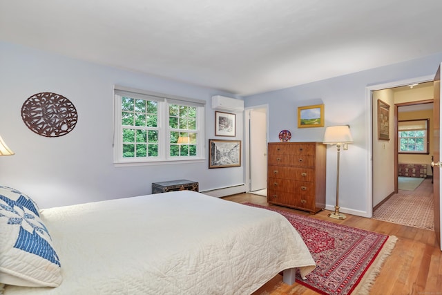 10 Crossland Pl, Norwalk, CT 06851 - bedroom featuring a wall unit AC, baseboard heating, multiple windows, and wood finished floors