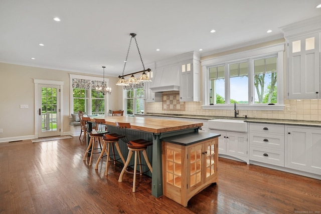 128 Chestnut Hill Rd, Killingworth, CT 06419 - kitchen with wooden counters, a kitchen island, backsplash, ornamental molding, and white cabinets