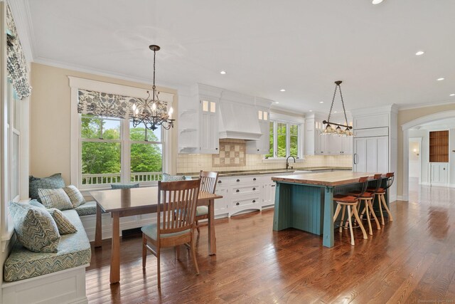 128 Chestnut Hill Rd, Killingworth, CT 06419 - kitchen with wooden counters, a chandelier, custom exhaust hood, white cabinetry, and crown molding