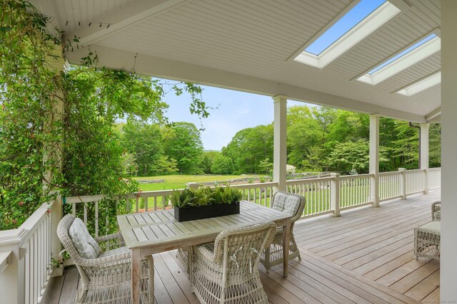 128 Chestnut Hill Rd, Killingworth, CT 06419 - wooden deck featuring outdoor dining space, view of scattered trees, and a lawn