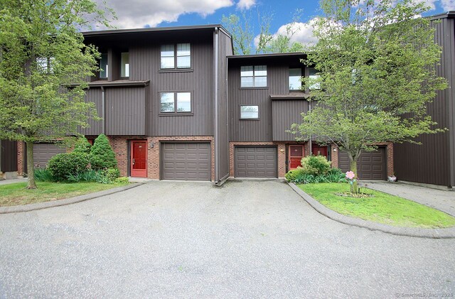198 Mattabasset Dr Unit 198, Meriden, CT 06450 - view of property with driveway, brick siding, and a garage