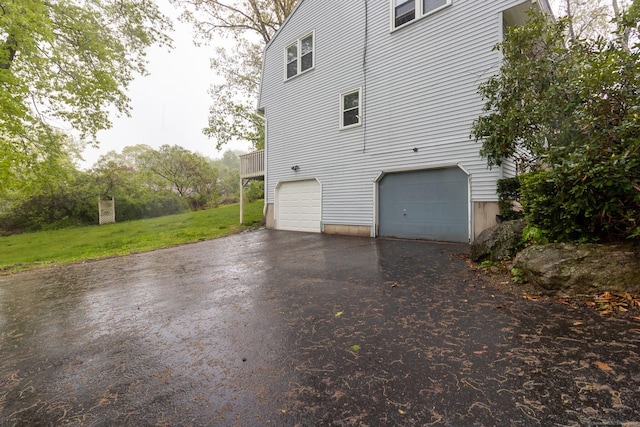 146 Macarthur Dr Unit 2B, Waterbury, CT 06704 - view of property exterior with asphalt driveway, an attached garage, and a yard