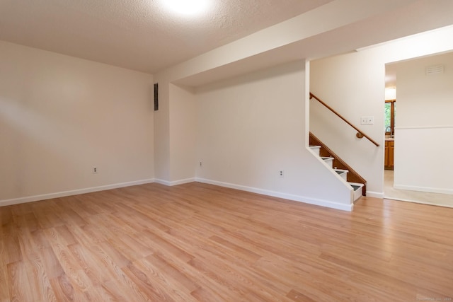 146 Macarthur Dr Unit 2B, Waterbury, CT 06704 - spare room with light wood-style flooring, stairway, baseboards, and a textured ceiling