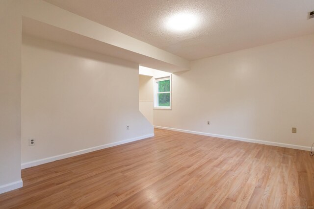 146 Macarthur Dr Unit 2B, Waterbury, CT 06704 - empty room featuring light wood-type flooring, baseboards, and a textured ceiling