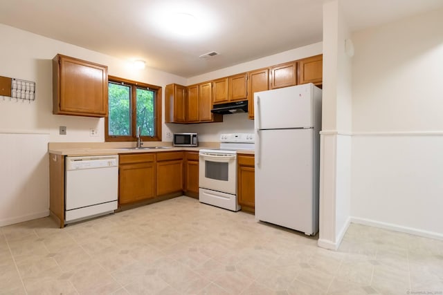 146 Macarthur Dr Unit 2B, Waterbury, CT 06704 - kitchen with white appliances, under cabinet range hood, a sink, brown cabinetry, and light countertops