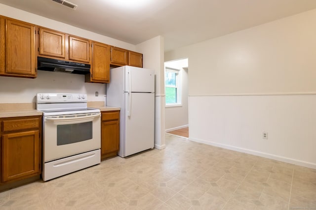 146 Macarthur Dr Unit 2B, Waterbury, CT 06704 - kitchen with white appliances, under cabinet range hood, light countertops, and brown cabinets