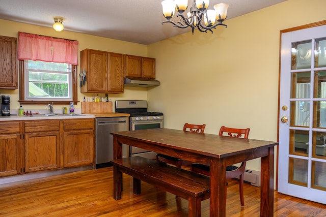 138 Baltic Hanover Rd, Sprague, CT 06330 - kitchen with stainless steel appliances, under cabinet range hood, a sink, a chandelier, and light wood-style floors