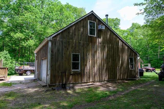 138 Baltic Hanover Rd, Sprague, CT 06330 - view of side of home with board and batten siding, a detached garage, and a wall mounted AC