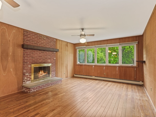 37 Windsor Ln, Greenwich, CT 06807 - unfurnished living room featuring ceiling fan, hardwood / wood-style flooring, a baseboard heating unit, wooden walls, and a brick fireplace