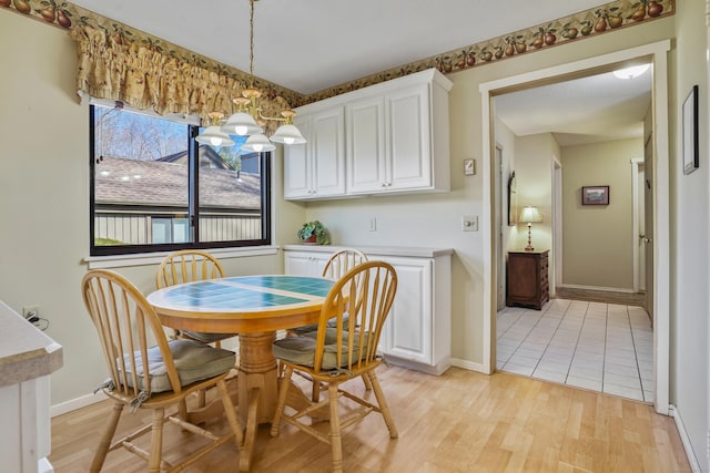 78 Heritage Vlg Unit A, Southbury, CT 06488 - dining area featuring a chandelier, baseboards, and light wood-type flooring