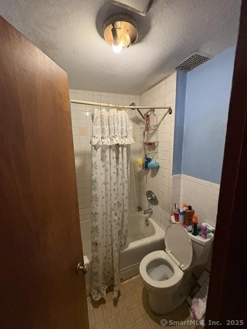 50 N St, Manchester, CT 06042 - bathroom featuring shower / bath combo with shower curtain, toilet, a textured ceiling, and tile walls