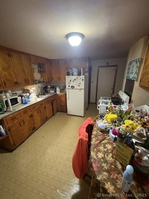 50 N St, Manchester, CT 06042 - kitchen featuring white appliances, brown cabinets, light countertops, and a sink