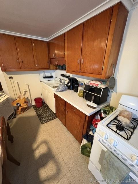 50 N St, Manchester, CT 06042 - kitchen with white gas range oven, light countertops, and brown cabinets