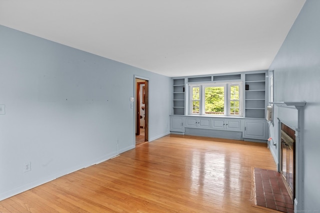 10 Richmond Rd, West Hartford, CT 06117 - unfurnished living room featuring a fireplace with flush hearth, built in features, light wood-style floors, and baseboards