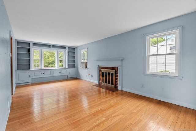 10 Richmond Rd, West Hartford, CT 06117 - unfurnished living room with built in features, light wood finished floors, a brick fireplace, baseboards, and cooling unit