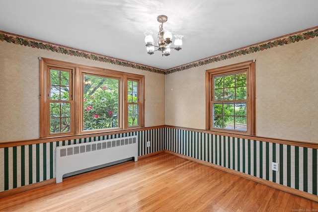 10 Richmond Rd, West Hartford, CT 06117 - spare room featuring radiator heating unit, wood finished floors, a chandelier, wallpapered walls, and plenty of natural light