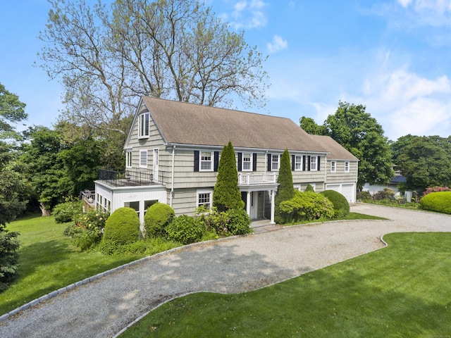 440 Hilltop Rd, Bridgeport, CT 06605 - view of front facade featuring gravel driveway, a front yard, an attached garage, roof with shingles, and a balcony