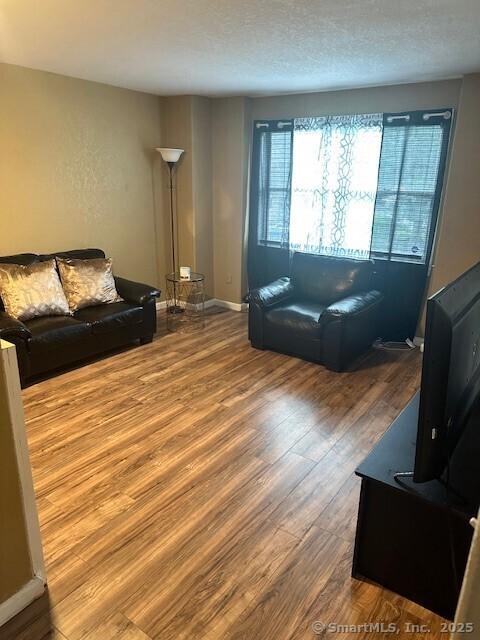 243 Lawlor St Apt 2C, New Britain, CT 06051 - living area featuring wood finished floors and baseboards