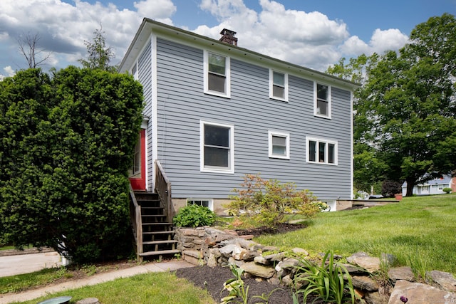 7 Lawrence Ave, North Canaan, CT 06018 - view of home's exterior featuring a chimney, a yard, and stairs