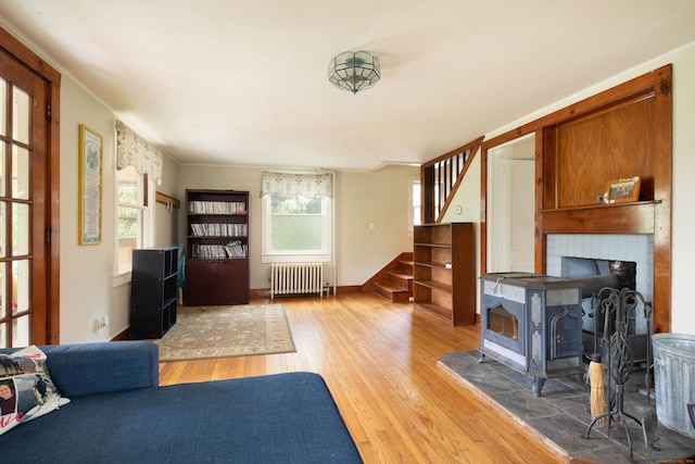 7 Lawrence Ave, North Canaan, CT 06018 - living area with radiator heating unit, wood finished floors, stairway, healthy amount of natural light, and crown molding