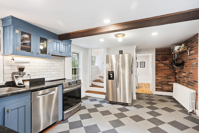 291 Hopmeadow St, Simsbury, CT 06089 - kitchen featuring appliances with stainless steel finishes, dark floors, blue cabinets, and brick wall