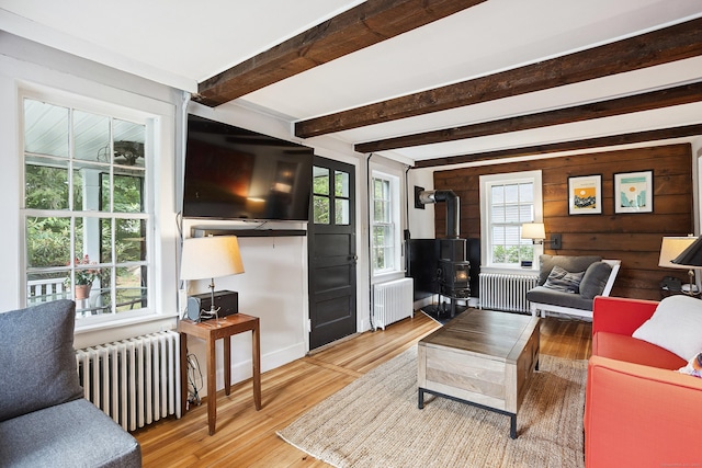 291 Hopmeadow St, Simsbury, CT 06089 - living area with radiator heating unit, a wood stove, wood finished floors, and beam ceiling
