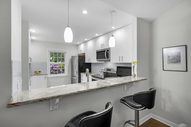 26 Legend Hill Rd Unit 26, Madison, CT 06443 - kitchen with stainless steel appliances, white cabinets, backsplash, light stone counters, and recessed lighting