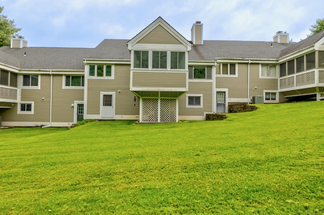 26 Legend Hill Rd Unit 26, Madison, CT 06443 - back of house with a sunroom, a lawn, a chimney, and a shingled roof