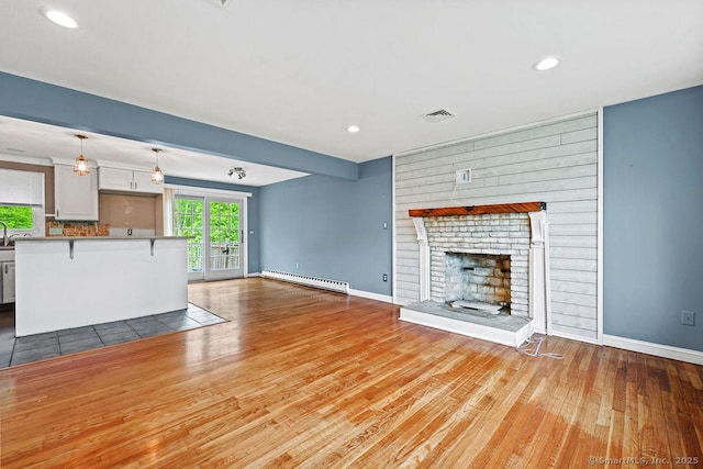 99 Redwood Dr, Bristol, CT 06010 - unfurnished living room featuring a baseboard radiator, wood finished floors, baseboards, a fireplace, and recessed lighting